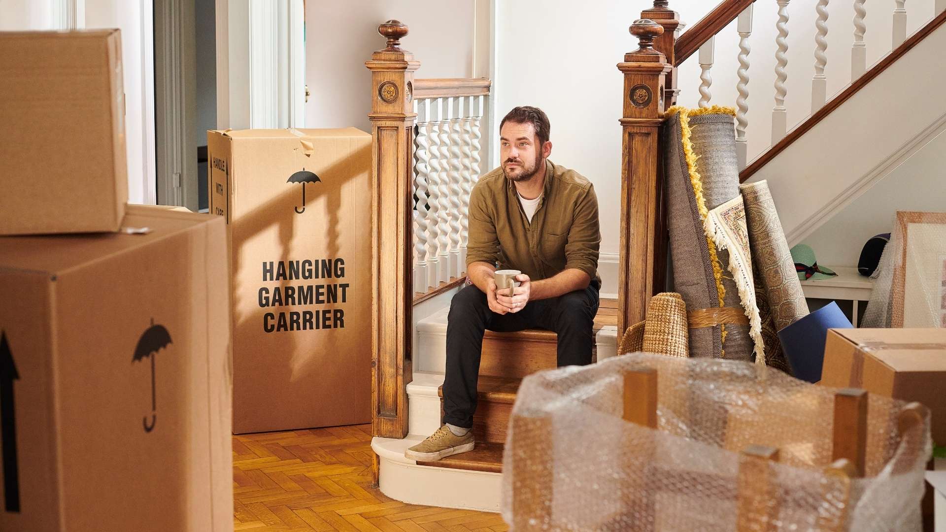 a man sitting on the stairs around boxes